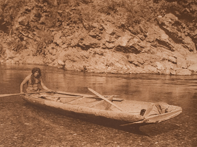An Edward Curtis photo of a Yurok man in a canoe on Trinity River